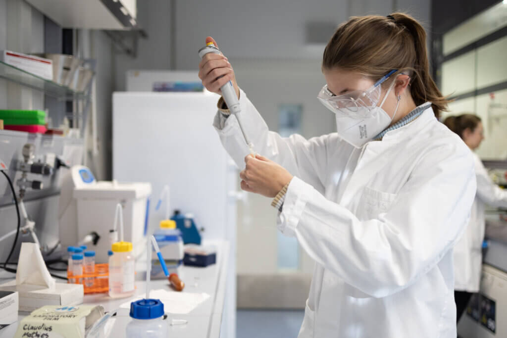 Wissenschaftlerin im Labor füllt etwas mit einer Pipette ab